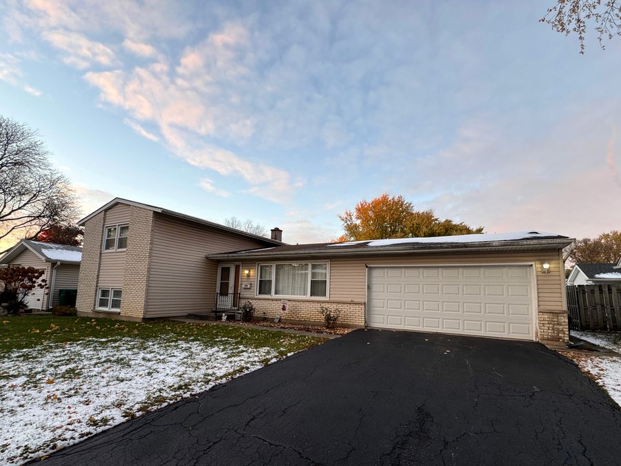 Split-level home with attached garage in Buffalo Grove, IL at dusk