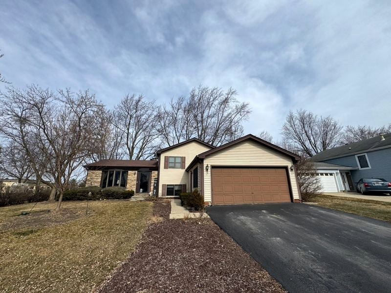 Split-level home in Lake Zurich, IL with brown shutters and a brown garage door