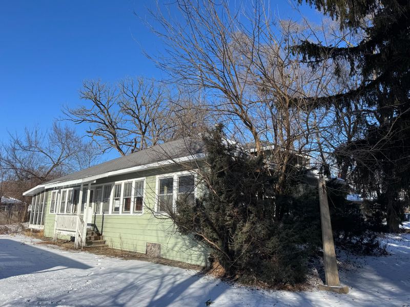 Green ranch home in McHenry, IL on a snowy lot